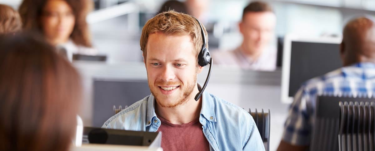 988 operator with headset on desktop computer