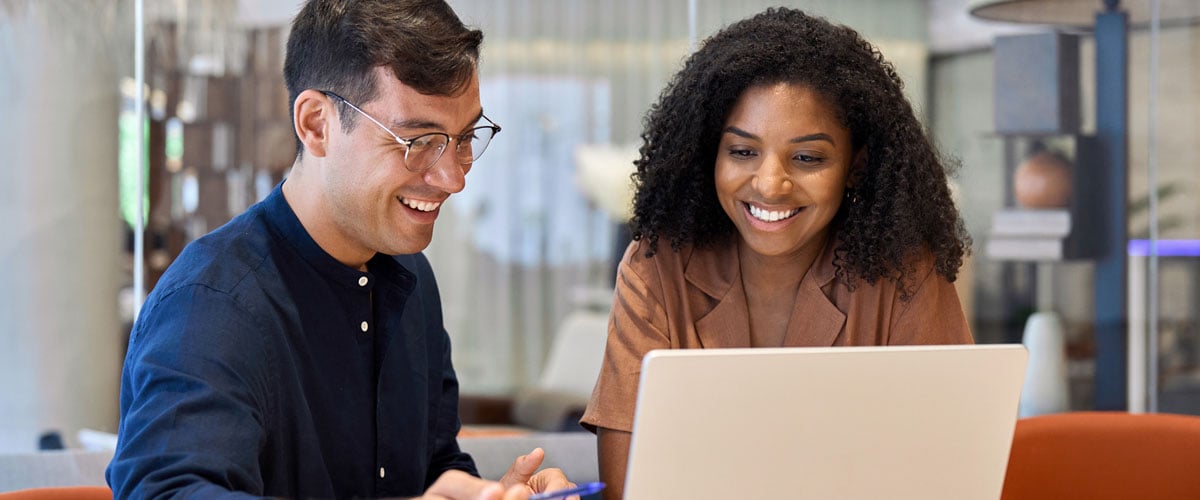 Two professionals looking at a laptop